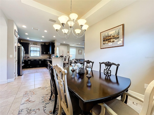 tiled dining space featuring an inviting chandelier