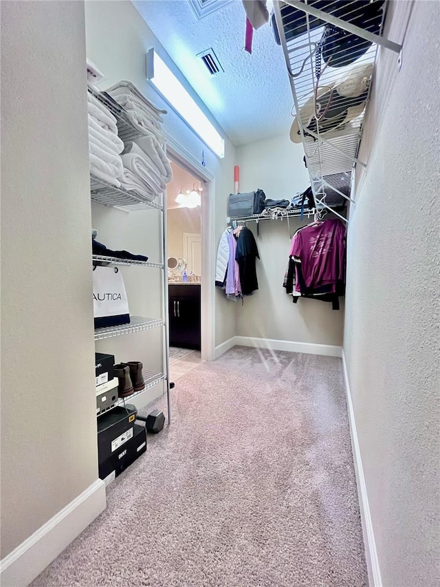 walk in closet featuring carpet flooring