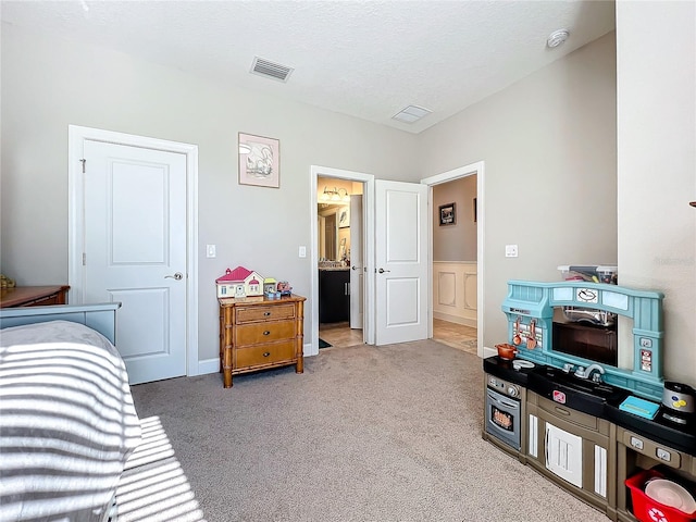 bedroom with light carpet and a textured ceiling