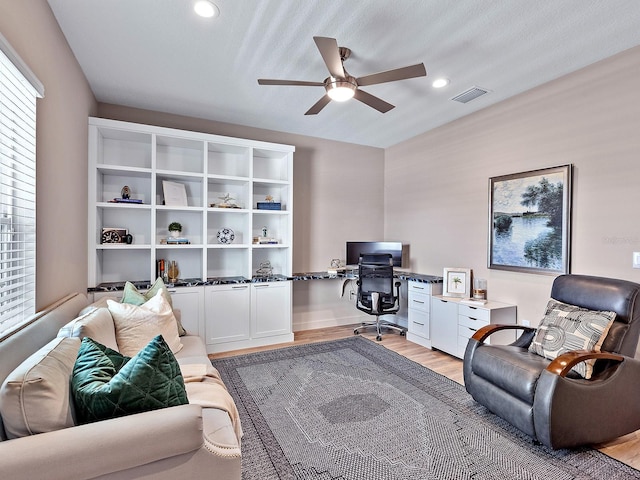 office space featuring a textured ceiling, ceiling fan, and light hardwood / wood-style floors