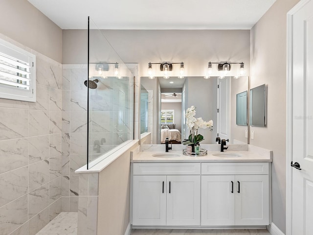 bathroom featuring tiled shower, vanity, and a healthy amount of sunlight