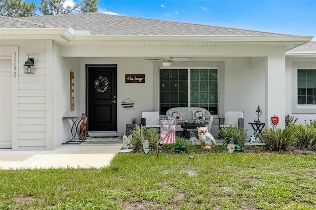 doorway to property featuring a lawn and ceiling fan