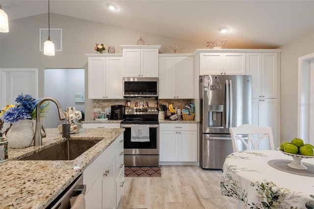 kitchen with light hardwood / wood-style floors, stainless steel appliances, sink, decorative backsplash, and lofted ceiling