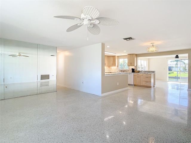 unfurnished living room featuring ceiling fan and sink