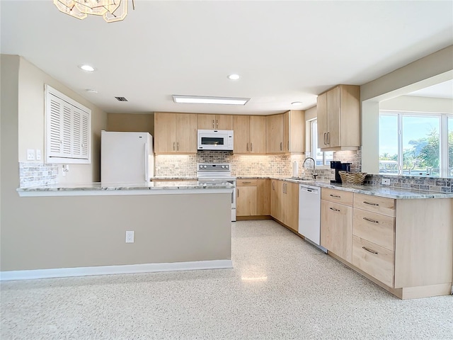 kitchen with white appliances, sink, light brown cabinets, and decorative backsplash