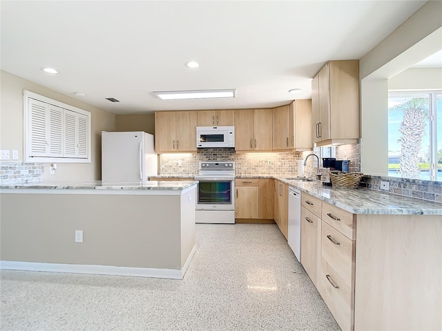 kitchen featuring white appliances, backsplash, light brown cabinetry, sink, and light stone countertops