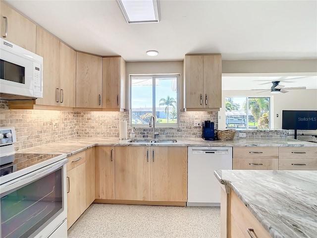 kitchen with white appliances, sink, light brown cabinets, decorative backsplash, and a wealth of natural light