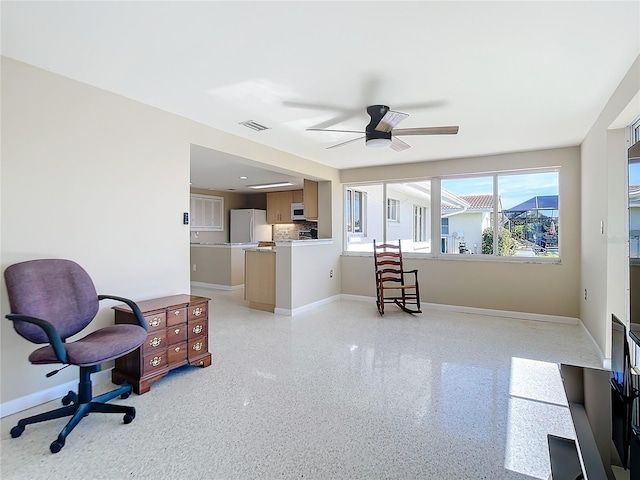 interior space featuring visible vents, baseboards, light speckled floor, and a ceiling fan