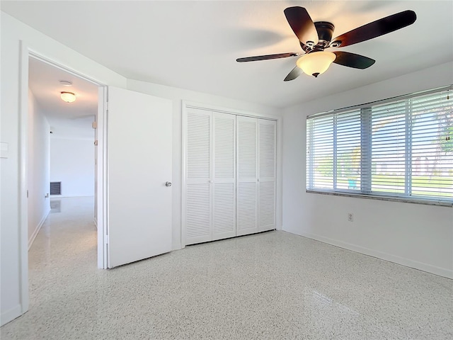 unfurnished bedroom with ceiling fan and a closet