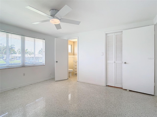 unfurnished bedroom with ensuite bath, ceiling fan, and a closet