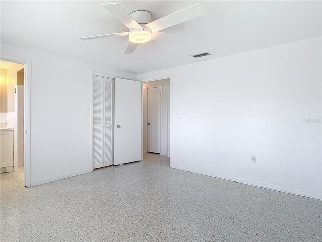 unfurnished bedroom with visible vents, ceiling fan, ensuite bathroom, light speckled floor, and a closet