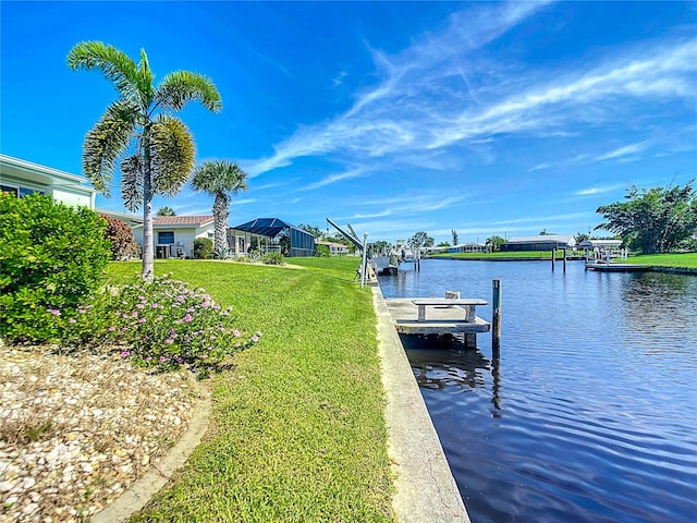 view of dock with a water view and a lawn