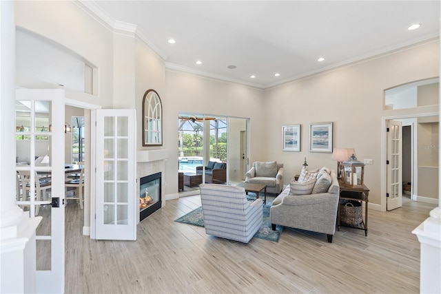 living room with french doors, light hardwood / wood-style floors, and ornamental molding