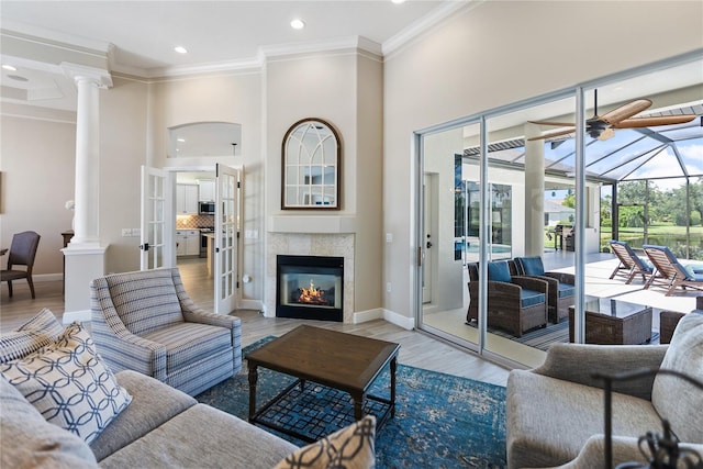 living room with crown molding, french doors, a towering ceiling, and light wood-type flooring