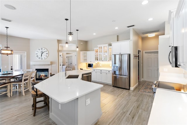 kitchen with pendant lighting, a large island, white cabinetry, and stainless steel appliances