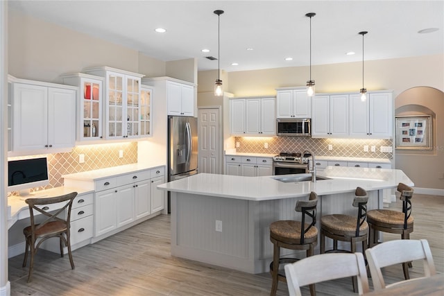 kitchen with sink, white cabinets, decorative light fixtures, and appliances with stainless steel finishes