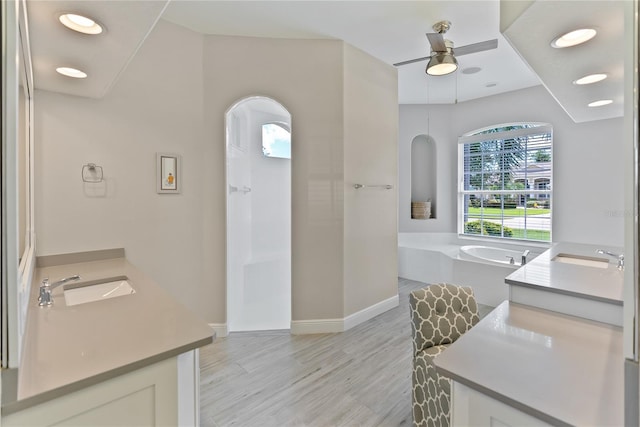 bathroom with vanity, hardwood / wood-style flooring, ceiling fan, and a tub