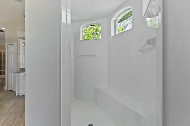 bathroom featuring tiled shower, vanity, a textured ceiling, and hardwood / wood-style flooring