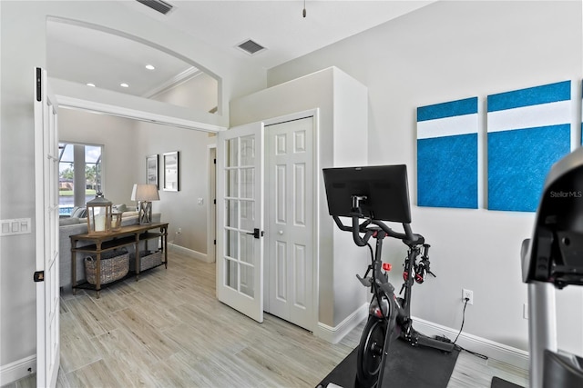 workout area featuring french doors and light hardwood / wood-style floors