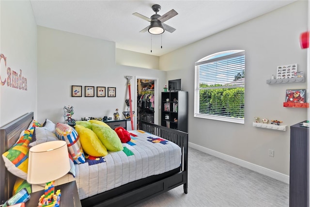 bedroom with ceiling fan, light colored carpet, and a closet