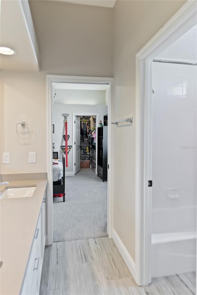 bathroom with hardwood / wood-style flooring, vanity, and bathtub / shower combination