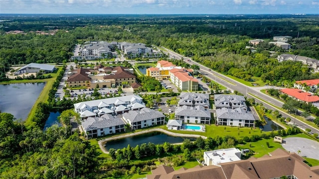 aerial perspective of suburban area with a heavily wooded area and a large body of water
