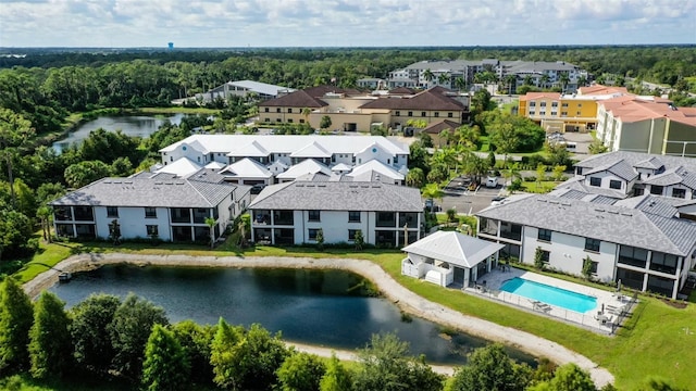 bird's eye view of a pool, a large body of water, and a forest