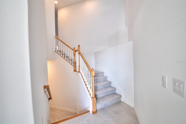 staircase with tile patterned floors and baseboards