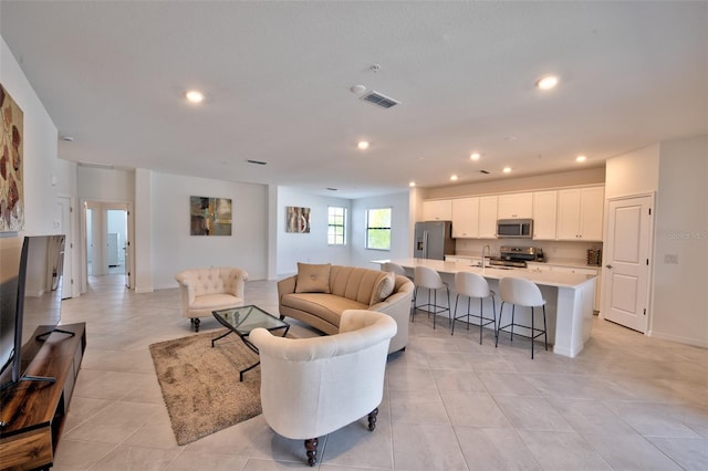 living area featuring recessed lighting and light tile patterned flooring