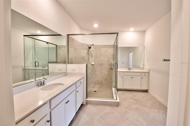 full bath with a stall shower, two vanities, tile patterned floors, and recessed lighting