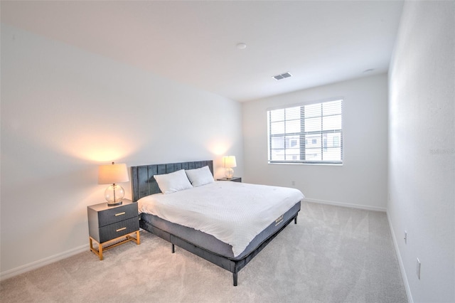 bedroom featuring light carpet and baseboards