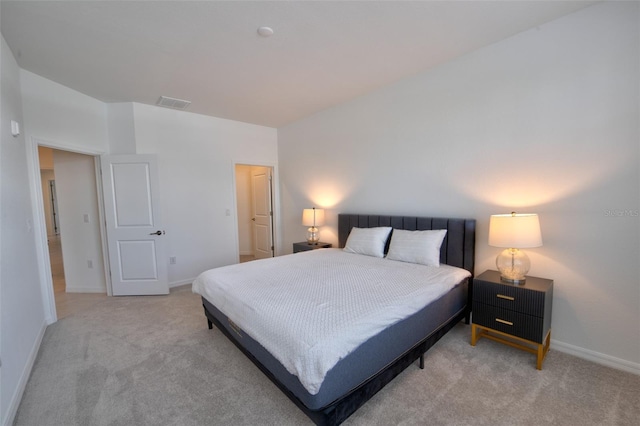 bedroom with light colored carpet and baseboards