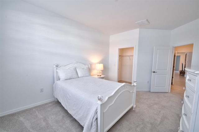 bedroom with light carpet, baseboards, a spacious closet, and a closet