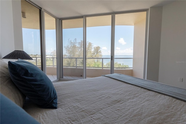 bedroom featuring expansive windows and a water view