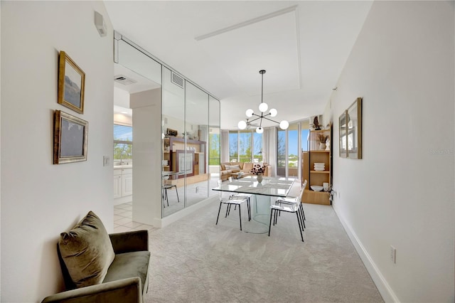 dining area featuring light carpet, a healthy amount of sunlight, and a chandelier