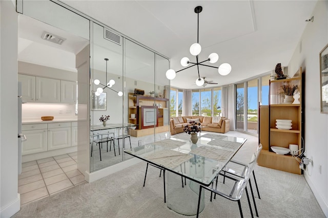 dining space with light tile patterned floors and ceiling fan with notable chandelier