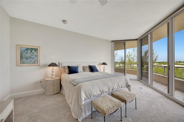 carpeted bedroom featuring expansive windows, access to outside, and ceiling fan