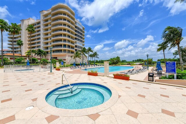 view of swimming pool featuring a community hot tub and a patio area