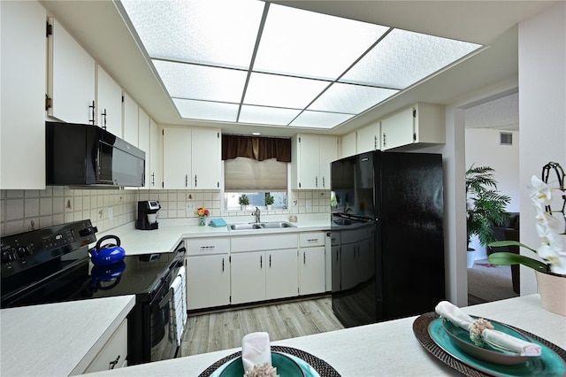 kitchen with backsplash, sink, black appliances, light hardwood / wood-style floors, and white cabinetry