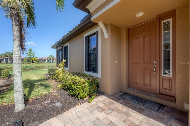 doorway to property featuring a lawn