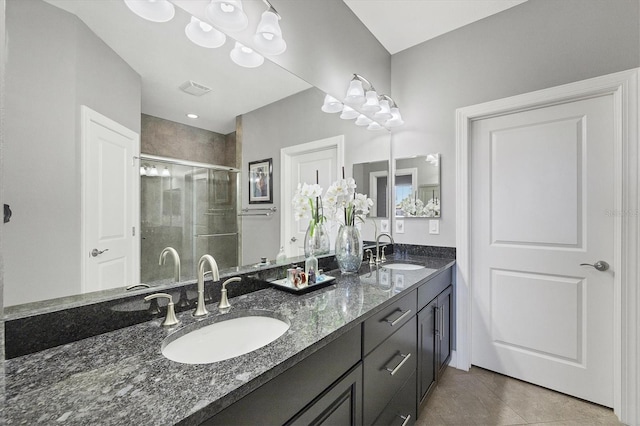 bathroom with tile patterned floors, a shower with shower door, and vanity