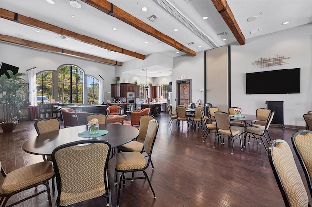 dining area featuring dark wood-type flooring and beamed ceiling