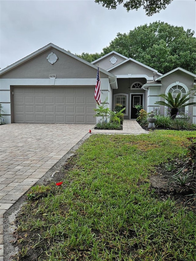 ranch-style house with a garage and a front yard