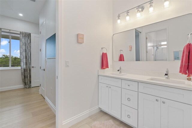 bathroom with hardwood / wood-style floors, vanity, and walk in shower