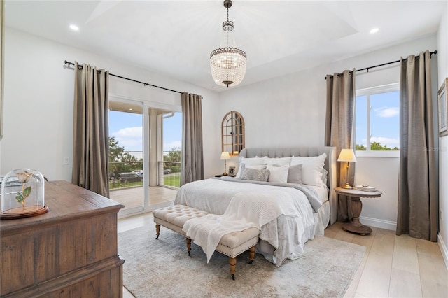 bedroom with a chandelier, access to outside, light hardwood / wood-style flooring, and multiple windows