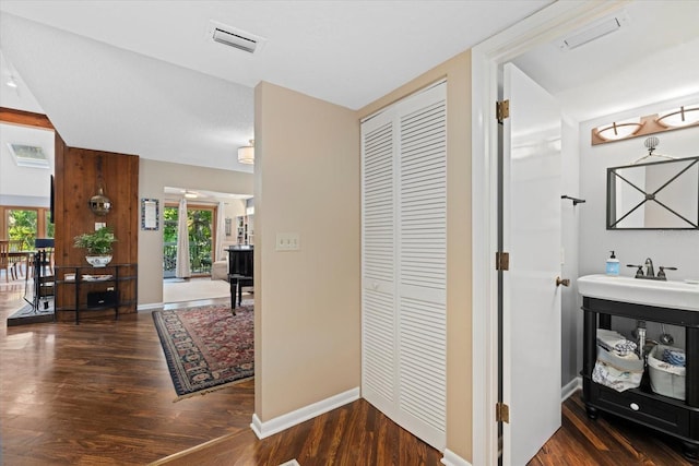 hall featuring a healthy amount of sunlight, dark hardwood / wood-style flooring, and sink