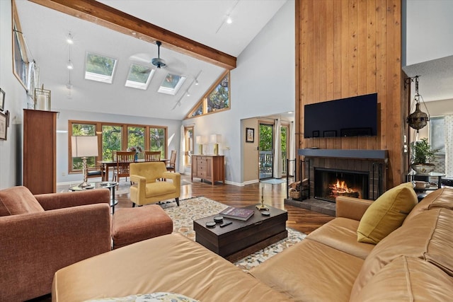 living room with ceiling fan, a fireplace, high vaulted ceiling, and a healthy amount of sunlight