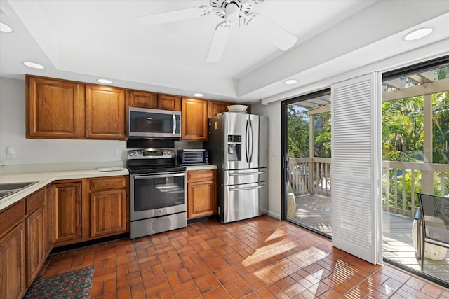 kitchen featuring appliances with stainless steel finishes, a tray ceiling, and ceiling fan