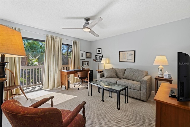 living room featuring ceiling fan, a healthy amount of sunlight, and a textured ceiling