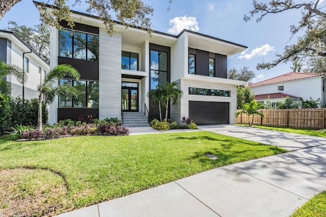 contemporary home featuring a front yard and a garage